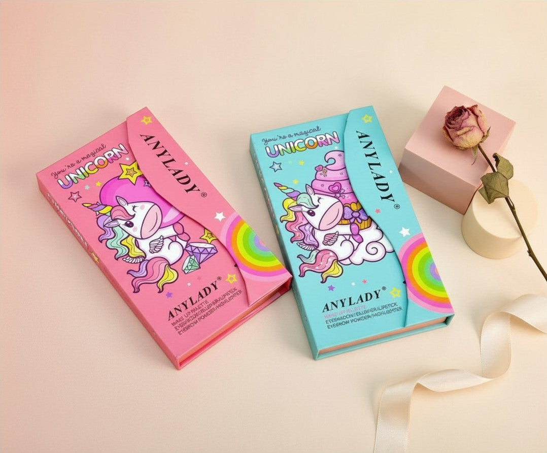 My Glam Room Anylady unicorn makeup palettes in pink and blue boxes with whimsical cartoon designs on a soft background