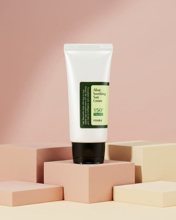 My Glam Room Cosrx Aloe Soothing Sun Cream SPF50+ PA+++ in a white tube on geometric blocks against a pink background