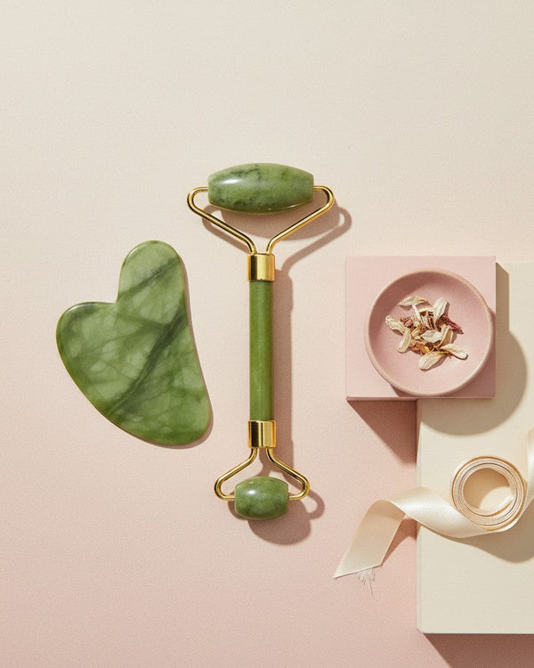 My Glam Room jade roller and heart-shaped gua sha massage tool set with gold accents on a soft pink background