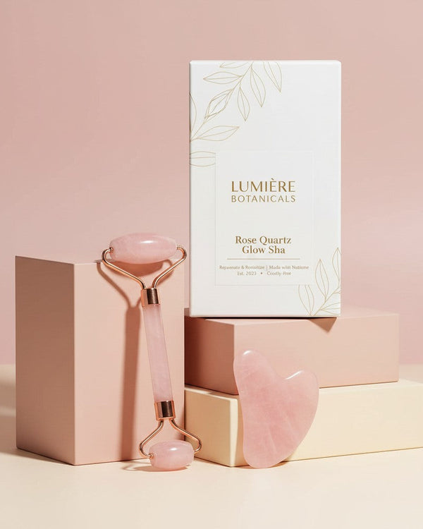 My Glam Room rose quartz jade roller and gua sha set with Lumiere Botanicals packaging on pastel display blocks