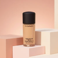 My Glam Room Mac Studio Fix Fluid SPF 15 foundation bottle in a glass container with a black cap on pastel blocks.