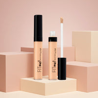My Glam Room Maybelline Fit Me concealer tubes with applicator wand on geometric display blocks