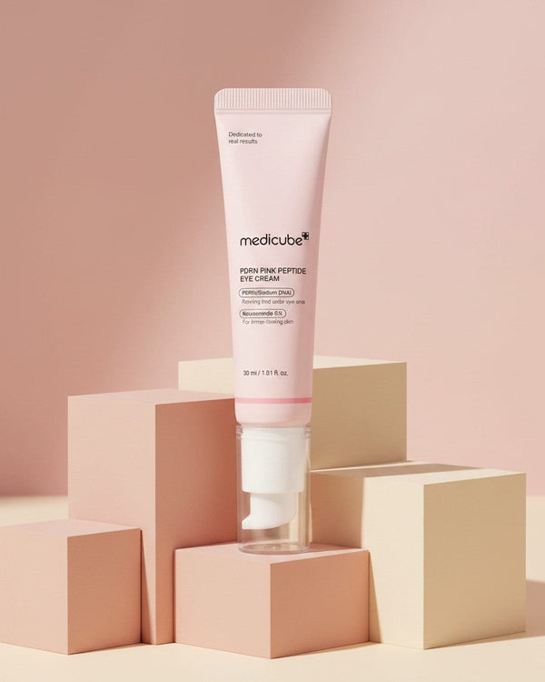 My Glam Room Medicube PDRN Pink Peptide eye cream in a soft pink tube displayed on geometric blocks