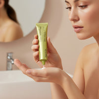 My Glam Room Arencia Vitamin C Booster Shot serum being applied to a woman's hand in a bright bathroom setting.