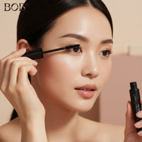 My Glam Room BOB 360 black dense mascara being applied by a woman with natural makeup for voluminous lashes