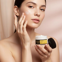 My Glam Room model applying Cosrx Advanced Snail 92 All in One Cream to her cheek from a white jar