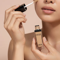 My Glam Room model applying Dior Forever Skin Correct full-coverage concealer with applicator on beige background