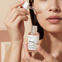 My Glam Room model applying The Ordinary Lactic Acid 10% + HA serum with a dropper onto her cheek
