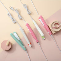 My Glam Room mini hair straighteners in pastel green, white, and pink arranged on a soft-toned background