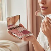 My Glam Room Charlotte Tilbury Pillow Talk face palette with blush and highlighter held by a woman using a brush