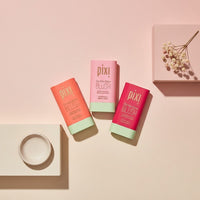 My Glam Room Pixi On the Glow Stick Blush collection in three shades with pink and coral packaging on a beige surface