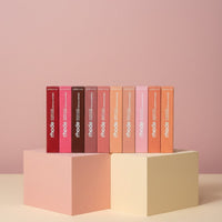 My Glam Room Rhode lip peptide treatment bundle featuring eight assorted shades in rectangular boxes on pedestals.