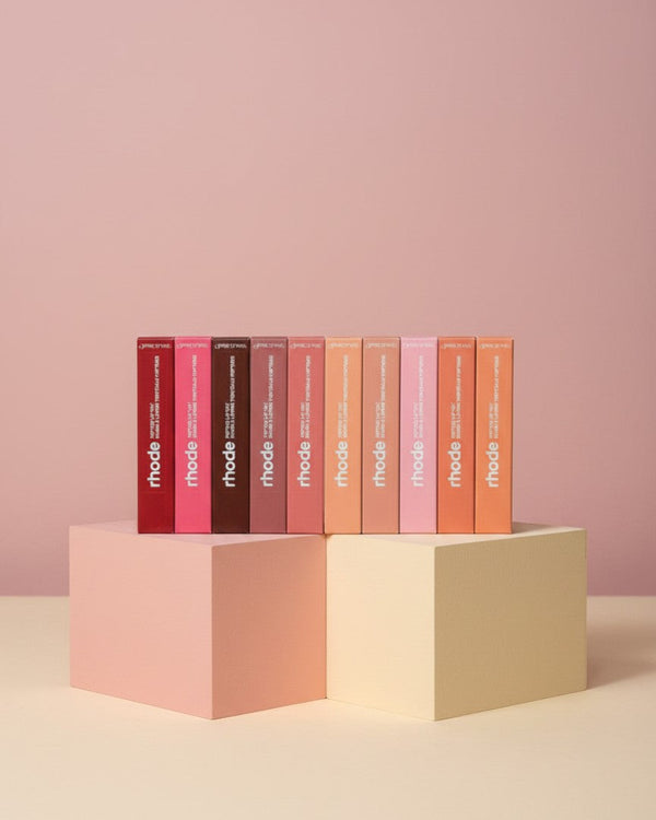 My Glam Room Rhode lip peptide treatment bundle featuring eight assorted shades in rectangular boxes on pedestals.