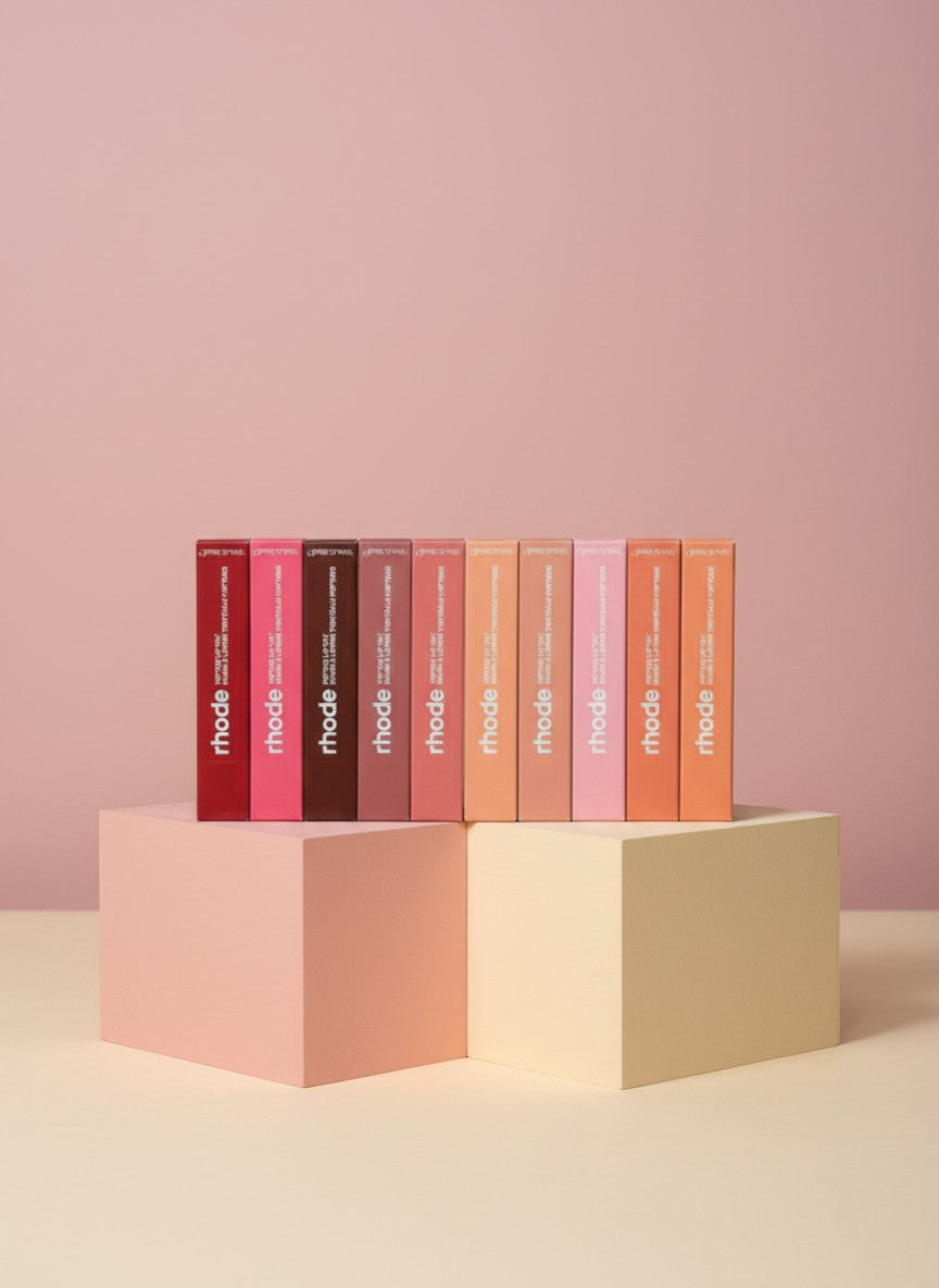 My Glam Room Rhode lip peptide treatment bundle featuring eight assorted shades in rectangular boxes on pedestals.