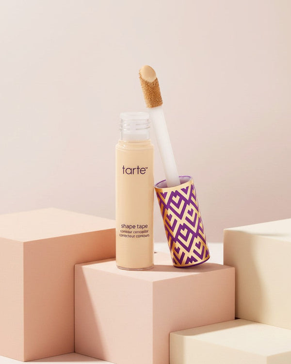 My Glam Room Tarte Shape Tape concealer with applicator wand on a soft pink geometric display block